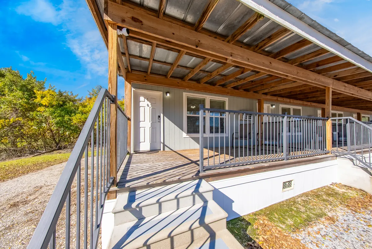 Covered porch with railed sections and steps outside the suites